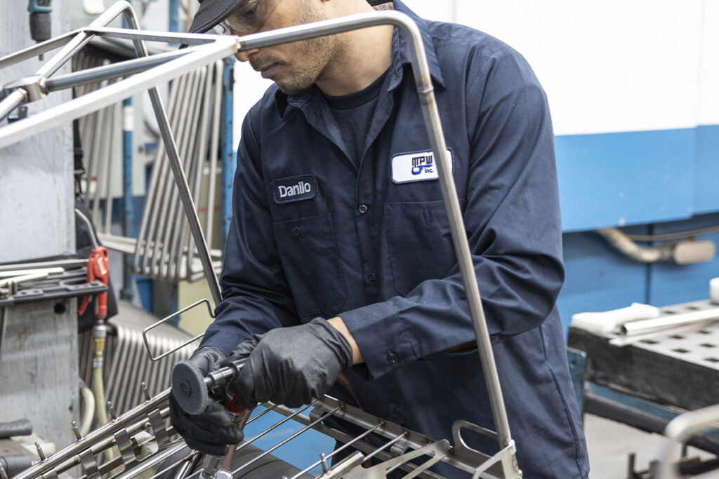 Une personne qui poli une pièce métallique.