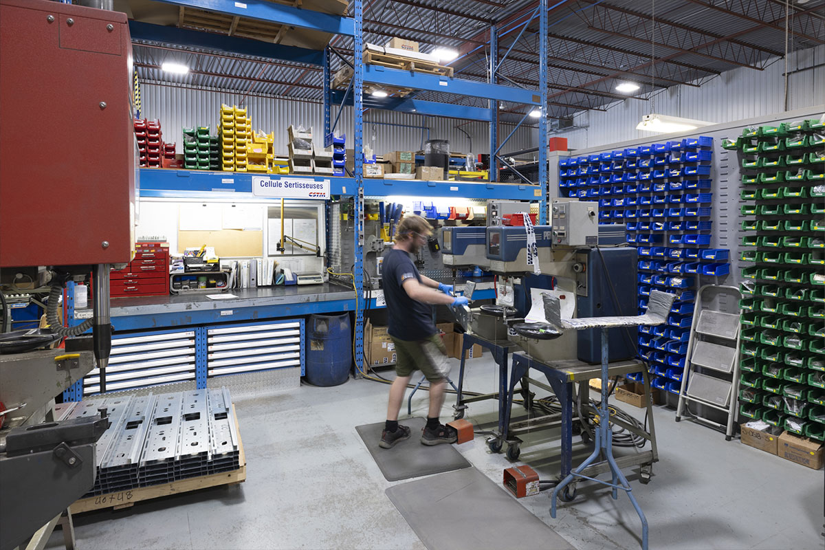 Un homme dans son environnement de travail dans l'usine, entouré de machine.